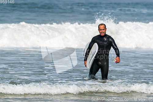 Image of Surfer with board under his arm