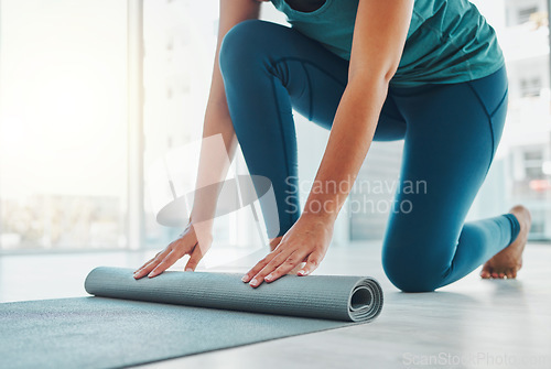 Image of Yoga, studio and exercise mat with the hands of a black woman at the start of a zen workout. Fitness, training and roll with a female yogi indoor for mental health, balance or spiritual wellness