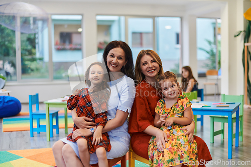 Image of A child hugging a teacher in a modern kindergarten