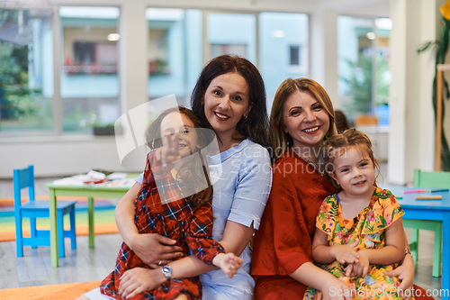 Image of A child hugging a teacher in a modern kindergarten