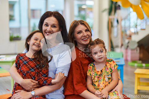 Image of A child hugging a teacher in a modern kindergarten