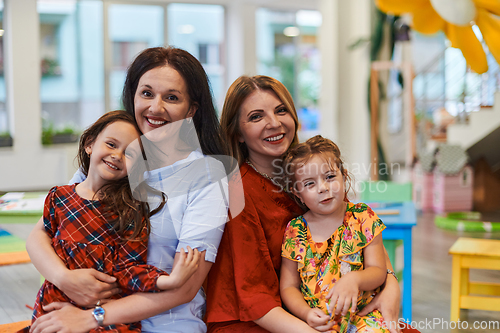 Image of A child hugging a teacher in a modern kindergarten