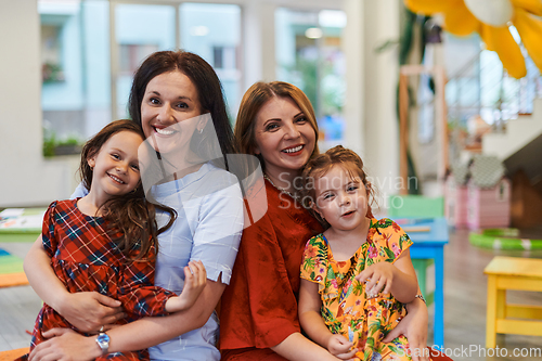 Image of A child hugging a teacher in a modern kindergarten