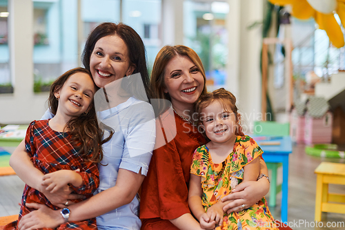 Image of A child hugging a teacher in a modern kindergarten