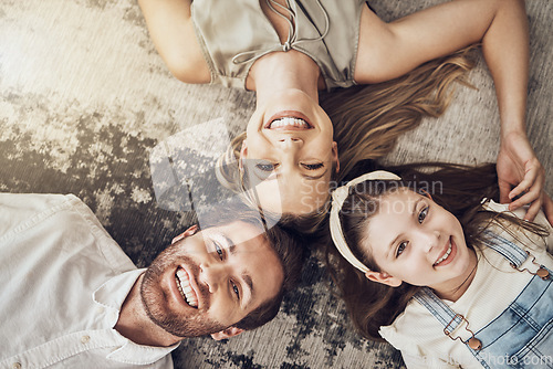Image of Portrait, mother or father with a child on floor relaxing as a happy family bonding in Australia with love or care. Carpet, top view or parents smile with girl enjoying quality time on a fun holiday