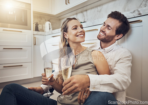 Image of Celebrate, love and couple with champagne in kitchen for honeymoon, anniversary and valentines day. Happy, relax and young man and woman drinking alcohol on the floor with conversation in marriage