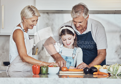 Image of Learning, grandparents or girl cooking as a happy family in a house kitchen with organic vegetables for dinner. Grandmother, old man and child helping or cutting carrots for a healthy vegan food diet
