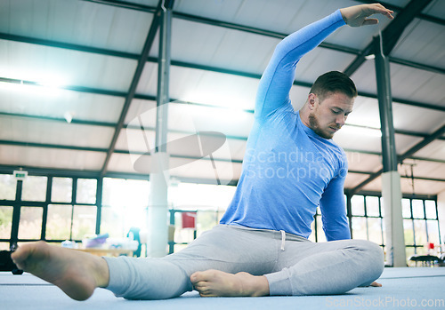 Image of Sports, gymnastics and man stretching body ready to start warm up for training, exercise and workout on floor. Fitness, motivation and male athlete with focus for balance, performance and competition