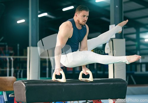 Image of Gymnastics, practice and man training for a competition, performance and exercise in a gym. Focus, fitness and athlete gymnast doing a movement with balance, strength and artistic with flexibility