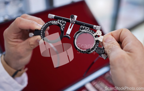 Image of Optometry, healthcare and optometrist with trial lens for a eye test in a optical clinic. Vision, eyecare and hands with a prescription optic instrument or glasses for a exam in a ophthalmology store