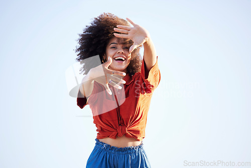 Image of Woman, portrait and hands over face outdoor for fashion on a blue sky background with summer mockup space. Beauty model person with natural hair, happy smile and unique style for freedom mindset