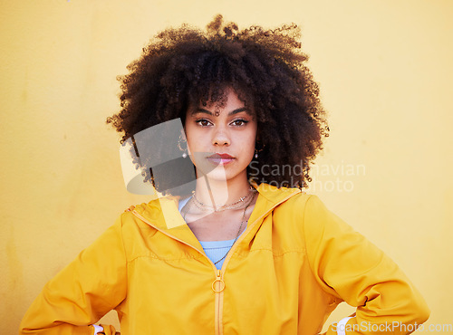 Image of Portrait, fashion and attitude with an afro black woman in studio on a yellow background for style. Trendy, hair and serious with an attractive young female posing alone on product placement space