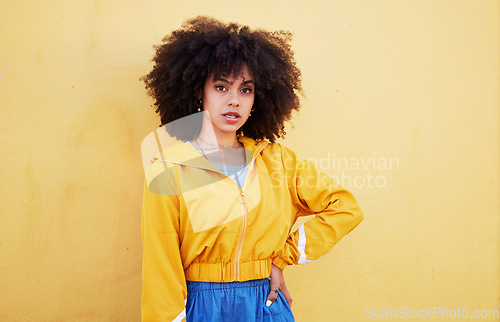 Image of Portrait, fashion and mock up with an afro black woman in studio on a yellow background for style. Trendy, hair and mockup with an attractive young female posing alone on product placement space