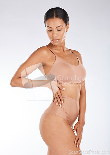 Image of Black woman, slim body and underwear in fitness, healthy diet or weight loss against a gray studio background. Young African American female model in sexy lingerie, wellness lifestyle or beauty