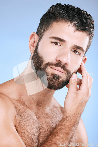Image of Skincare, portrait of man with beard and hand on face, morning cleaning treatment isolated on blue background. Facial hygiene, male model and grooming shave, health, wellness and skin care in studio.