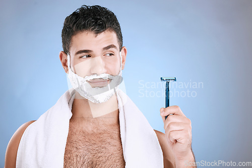 Image of Facial, foam on beard and man with razor in hand, towel and product placement and mock in studio. Shaving cream on face, hair and skincare for happy male model grooming, isolated on blue background.