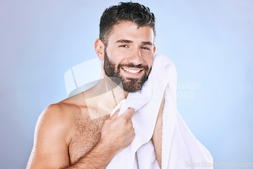 Image of Man, face and shower with hygiene, towel and beauty in portrait, smile and grooming in studio. Skincare, cosmetics and clean face with healthy skin, mockup and cosmetic care on blue background