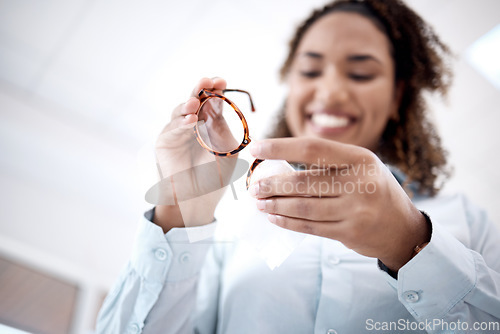 Image of Hands, cleaning glasses and black woman with cloth, happy or excited for healthy vision in optometry office. Young african lady, spectacles or smile for eyes, health or wellness with designer frame