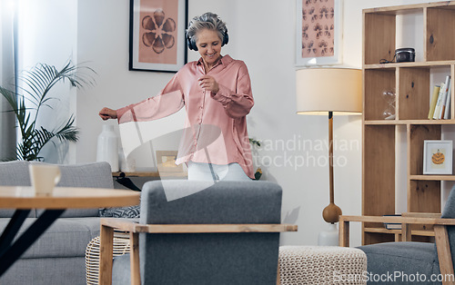 Image of Mature, music and woman with headphones for dance, freedom and streaming audio in the lounge. Fun, enjoyment and dancing elderly person with a podcast, radio or listening to a sound for happiness