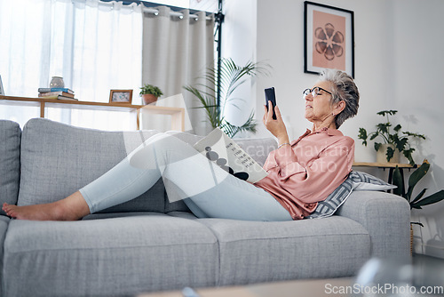 Image of Elderly woman check phone, communication and relax at home, social media with technology and reading book. .Retirement, internet and chat online with wifi, text message or email with news website