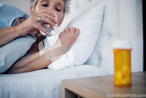 Image of Sick, mature and woman drinking water with medicine for pain, virus or insomnia in bed. Healthcare, flu and elderly person in the bedroom for sleep with pills for an illness, infection or cold