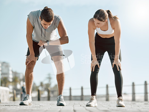 Image of Running, tired couple and watch for time, performance and goals on blue sky for wellness. Man and woman outdoor in nature for workout, fitness and exercise for healthy lifestyle and body fatigue