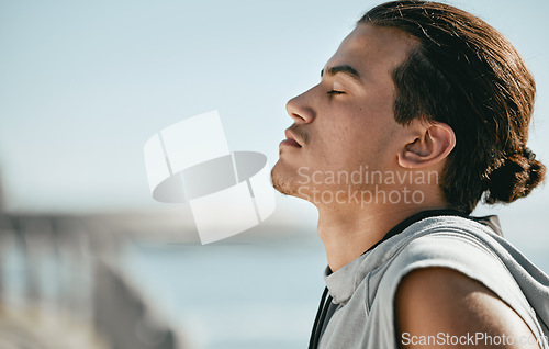 Image of Tired, fitness and breathing man for cardio training, workout or outdoor running break on blue sky mockup. Calm, thinking and athlete or sports person with exercise in summer by beach or ocean