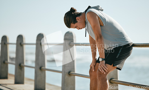 Image of Tired, workout and breathing man for fitness training, cardio or outdoor running break at beach. Breathe, thinking and fatigue of athlete or sports person with exercise challenge in summer by ocean