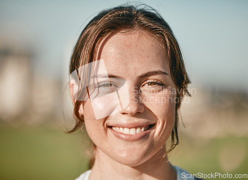 Image of Portrait, happy and smile with a woman outdoor on a bokeh green background for carefree positivity. Face, wellness and zoom with an attractive young female standing outside on a summer day in nature