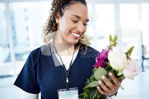 Image of Achievement, celebration and a doctor with flowers at a hospital for a promotion and gift for work. Care, happy and female nurse with a bouquet as a present for promotion in healthcare nursing job