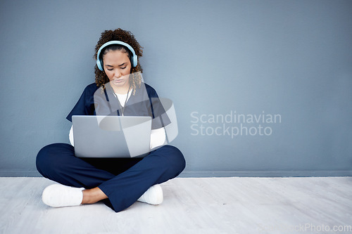 Image of Woman, laptop and headphones of hospital music, podcast or radio in woman study research or mockup nurse learning. Doctor, technology and medical student listening to healthcare audio for focus help
