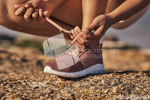 Image of Hands, fitness and tie shoes in nature to start running, workout or training. Sports, wellness and female or woman tying sneaker laces or footwear to get ready for exercising, cardio or jog outdoors.