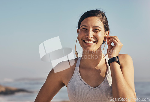 Image of Woman, fitness and portrait while listening to music at beach for exercise, training and workout. Happy model person face in nature with earphones for podcast, audio and motivation outdoor in nature