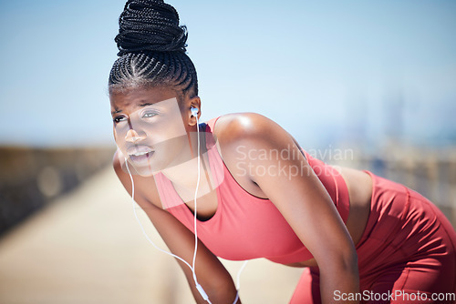 Image of Tired, breathing and black woman training for fitness, healthy target and body fatigue. Female athlete, break and breathe for sports workout, running and exercise with music earphones for challenge