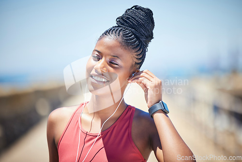 Image of Fitness, black woman and happy runner with earphones for training exercise outdoor. Face, smile and female athlete listening to music for sports motivation, healthy goals and audio of running workout