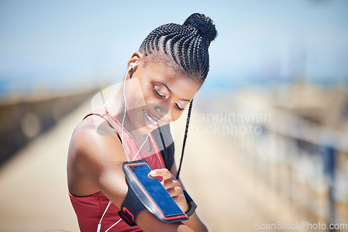 Image of Black woman, runner and arm band with phone, earphones and motivation for outdoor fitness. Happy female athlete, mobile music and training for exercise wellness, workout energy and sports technology