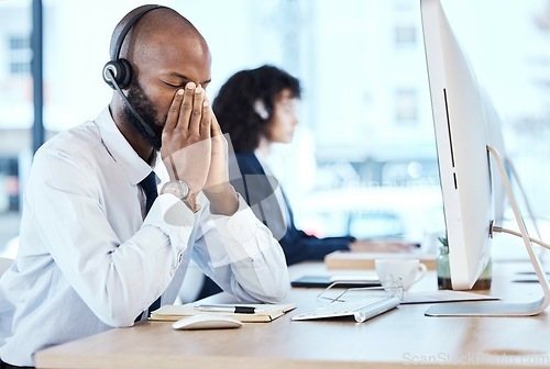 Image of Business, black man and stress in call center, headache and depression with telemarketing, burnout and tired. Corporate, African American male agent or consultant with computer, overworked or anxiety