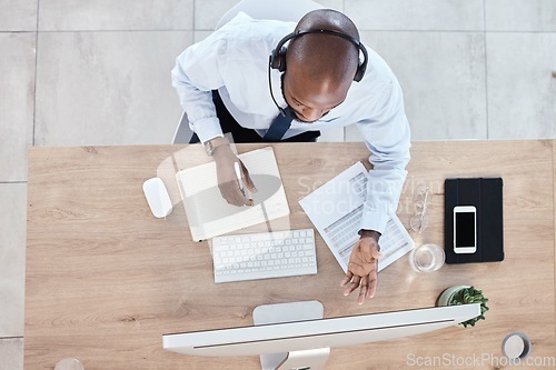 Image of Top view, black man or consultant in call center, customer service or talking with headset. African American male employee, agent or worker with computer, headphones or tech support to help in office