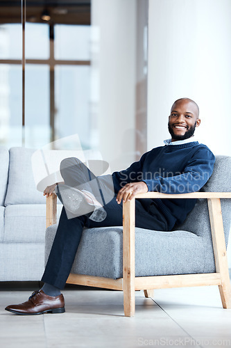 Image of Portrait, black man in office and waiting on chair, smile and confident for job interview, resting and relax. Face, African American male employee and entrepreneur in workplace, happiness and joyful