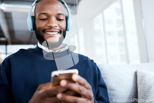 Image of Black man with smartphone, headphones and face, music and smile, scroll social media and audio streaming. Online, listening to radio or podcast with happiness and relax with texting or email