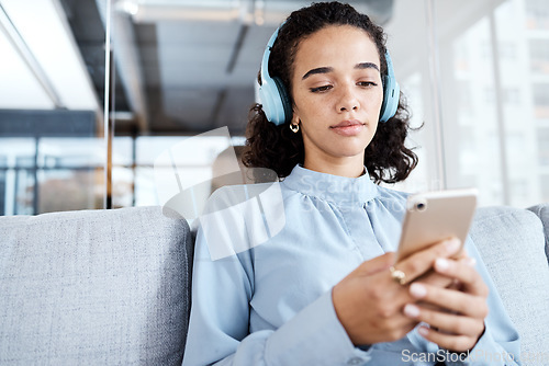 Image of Phone, music headphones and business woman on sofa in office streaming audio. Cellphone, relax technology and female employee on couch listening to podcast, radio or sound with mobile smartphone.