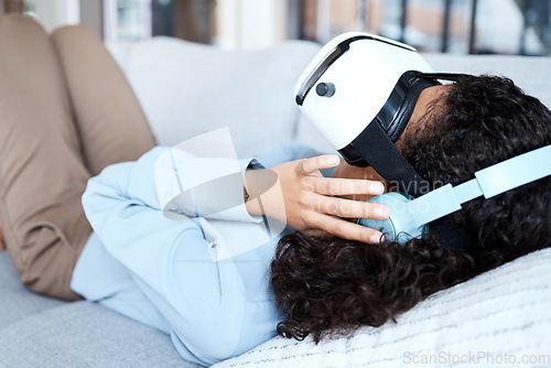 Image of Virtual reality, metaverse and gaming with a black woman on a sofa in the living room of her home. AI, 3D and VR with a young female gamer using a headset to access cyberspace for a video game