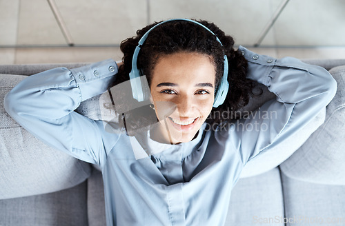 Image of Top view, portrait and woman on sofa, headphones and relax for break, peace and smile with joy. Female, lady and headset music, streaming and listen to podcast for happiness, cheerful and peaceful