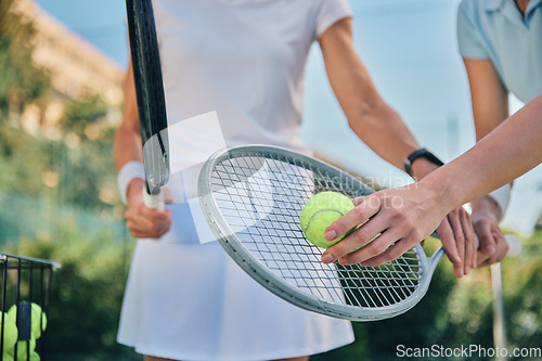 Image of Tennis training, hands and ball with women and athlete on outdoor turf, instructor or coach, fitness motivation and help. Exercise, sports lesson and workout together, teaching and learn on court