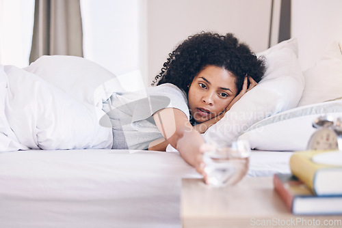 Image of Health, black woman in bed and wake up with water, tired and fatigue with burnout, overworked and sleepy. African American female, girl and in bedroom with aqua, illness and wellness in the morning