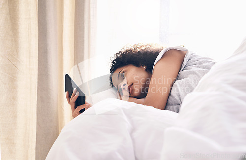 Image of Bed, black woman and typing on phone in home bedroom for social media, texting or internet browsing in the morning. Technology, relax and female with mobile smartphone for web scrolling or networking
