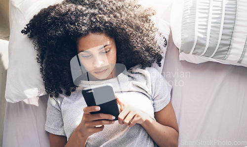 Image of Phone, black woman and top view in home bedroom for social media, texting or internet browsing in the morning. Technology, bed relax and female with mobile smartphone for web scrolling or networking.