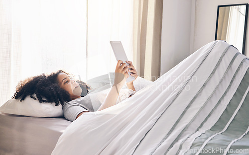 Image of Relax, black woman and tablet in bed in bedroom for social media, texting or internet browsing in the morning. Technology, home and female with digital touchscreen for web scrolling after waking up.