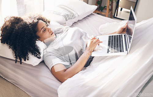 Image of Music earphones, woman and laptop in bed in bedroom for social media or internet browsing in the morning. Technology, relax or black female with computer for streaming podcast, audio or radio in home