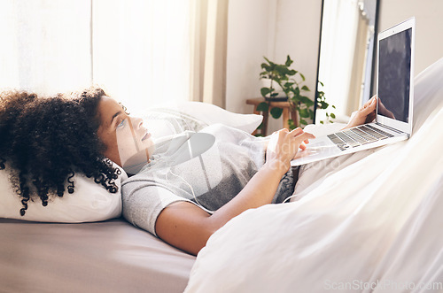 Image of Music earphones, laptop and woman in bed in bedroom for social media or internet browsing in the morning. Technology, relax or black female with computer for streaming podcast, audio or radio in home